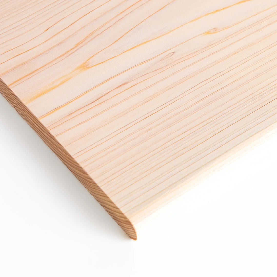 Hinoki wood cutting board with natural grain, engraved logo, and attached base for upright storage, combining beauty with everyday function.
