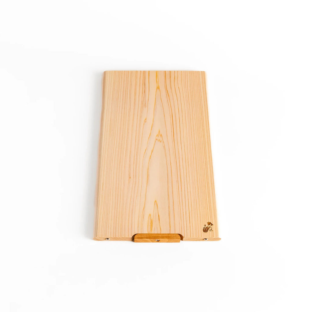 Hinoki wood cutting board with natural grain, engraved logo, and attached base for upright storage, combining beauty with everyday function.
