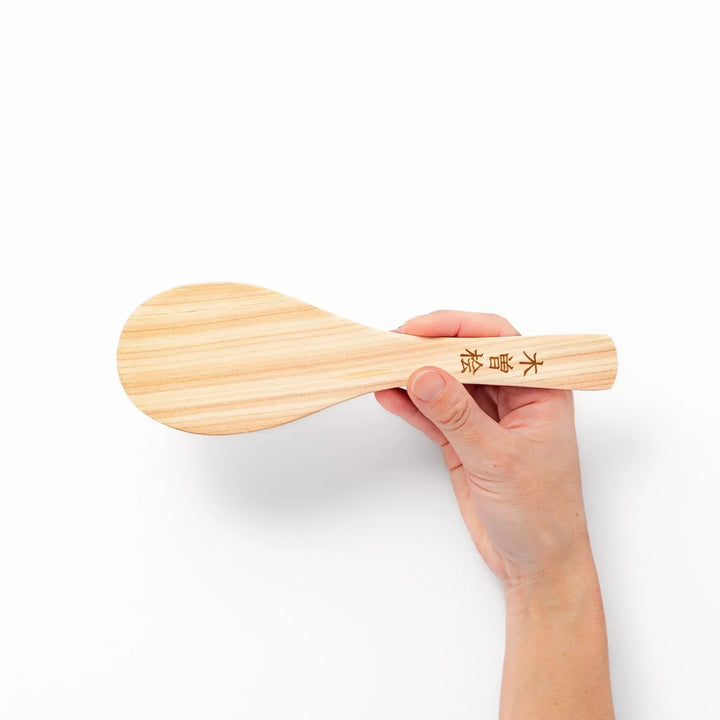 Japanese hinoki wood rice paddle with natural grain and engraved characters, lightweight and smooth for serving cooked rice