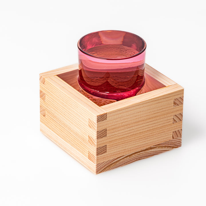 Pink sake glass with shimmering gold-leaf mountain design and a detailed Mount Fuji sculpted at the base, perfect for festive and elegant settings.