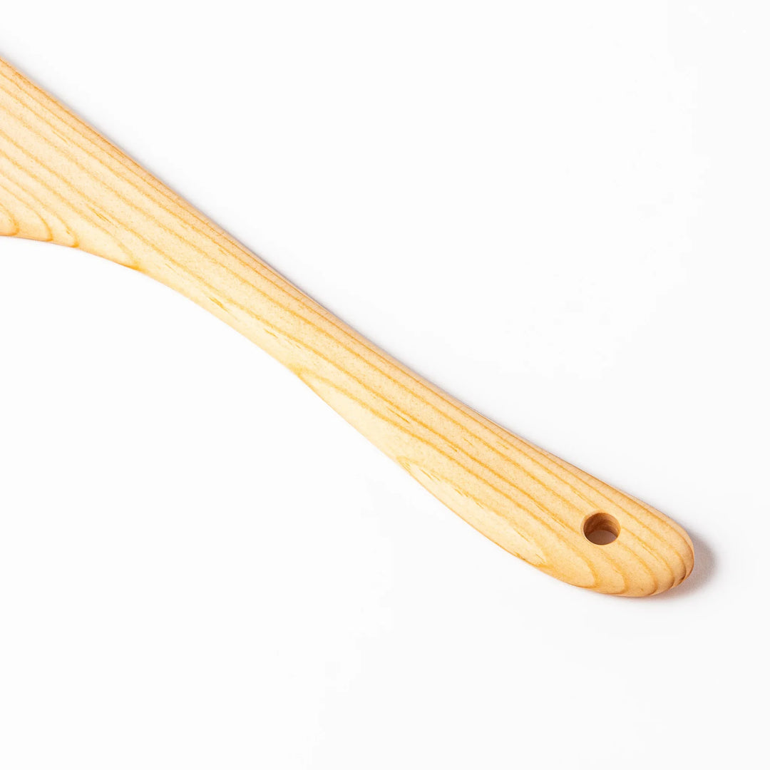 Curved spatula crafted from natural hinoki wood, featuring a wide paddle and smooth grain, perfect for stir-frying and gentle cooking tasks.