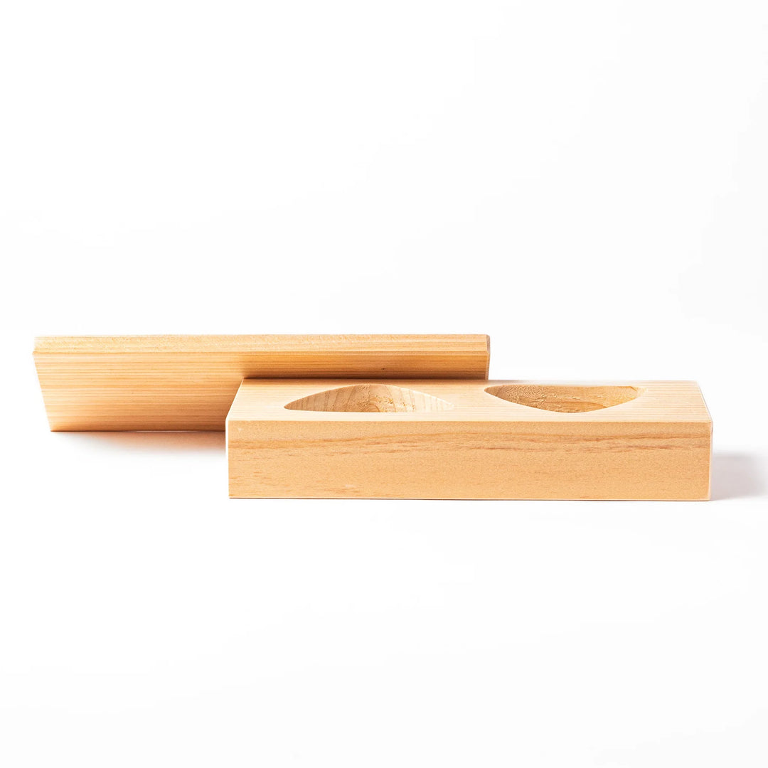 Hinoki wood onigiri mold with two triangle cavities and a matching lid, perfect for shaping traditional Japanese rice balls with ease and aroma.