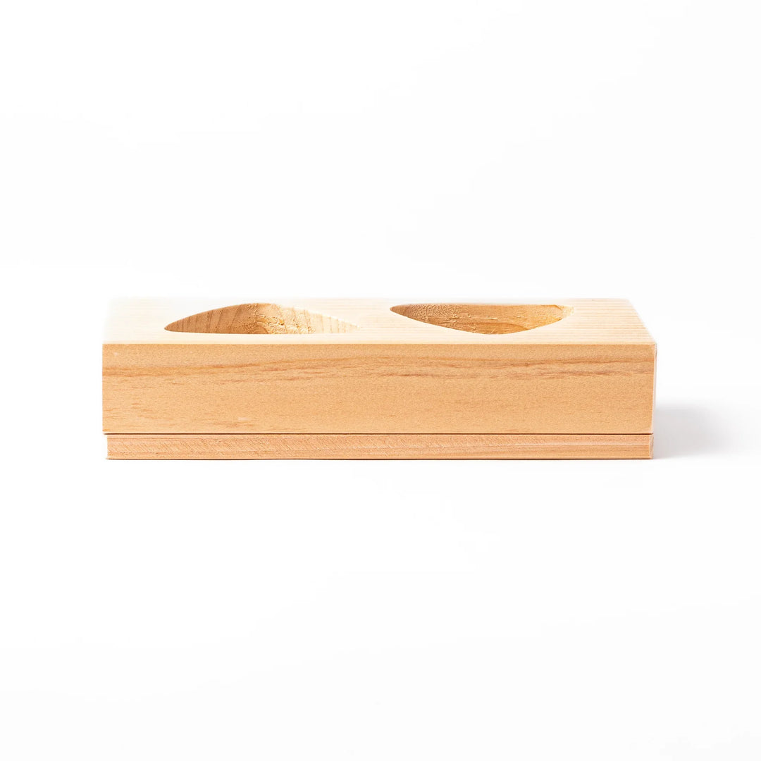 Hinoki wood onigiri mold with two triangle cavities and a matching lid, perfect for shaping traditional Japanese rice balls with ease and aroma.