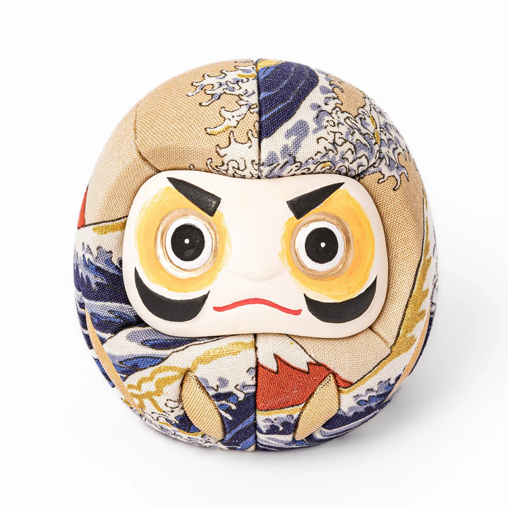 Fabric daruma ornament with bold Kabuki style face and wave pattern set on a small wooden display stand