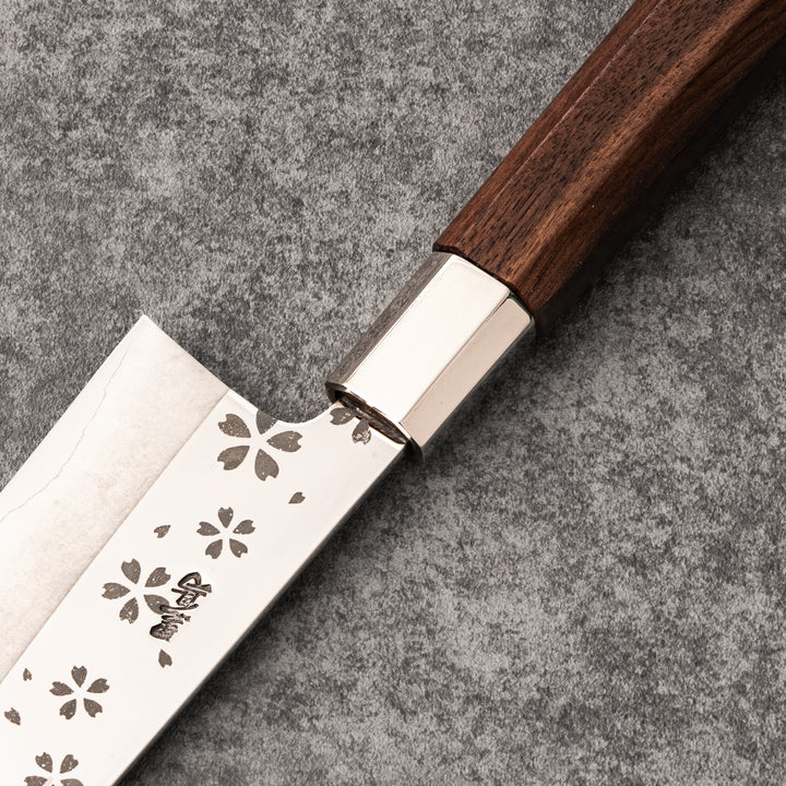 Elegant Japanese kitchen knife with cherry blossom cutout pattern on the blade, featuring a sharp edge and dark wooden handle for precise cutting.