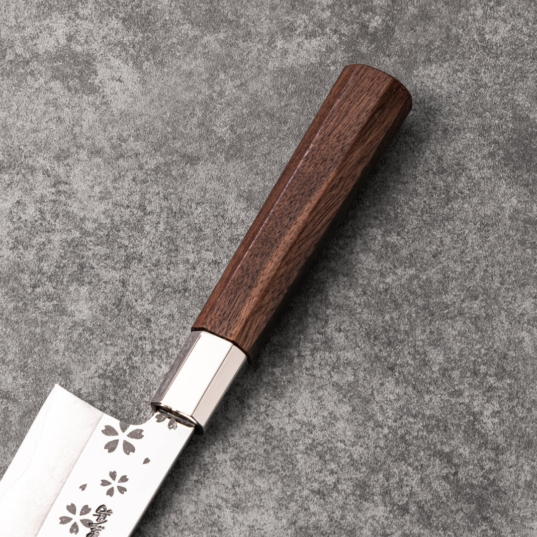 Elegant Japanese kitchen knife with cherry blossom cutout pattern on the blade, featuring a sharp edge and dark wooden handle for precise cutting.