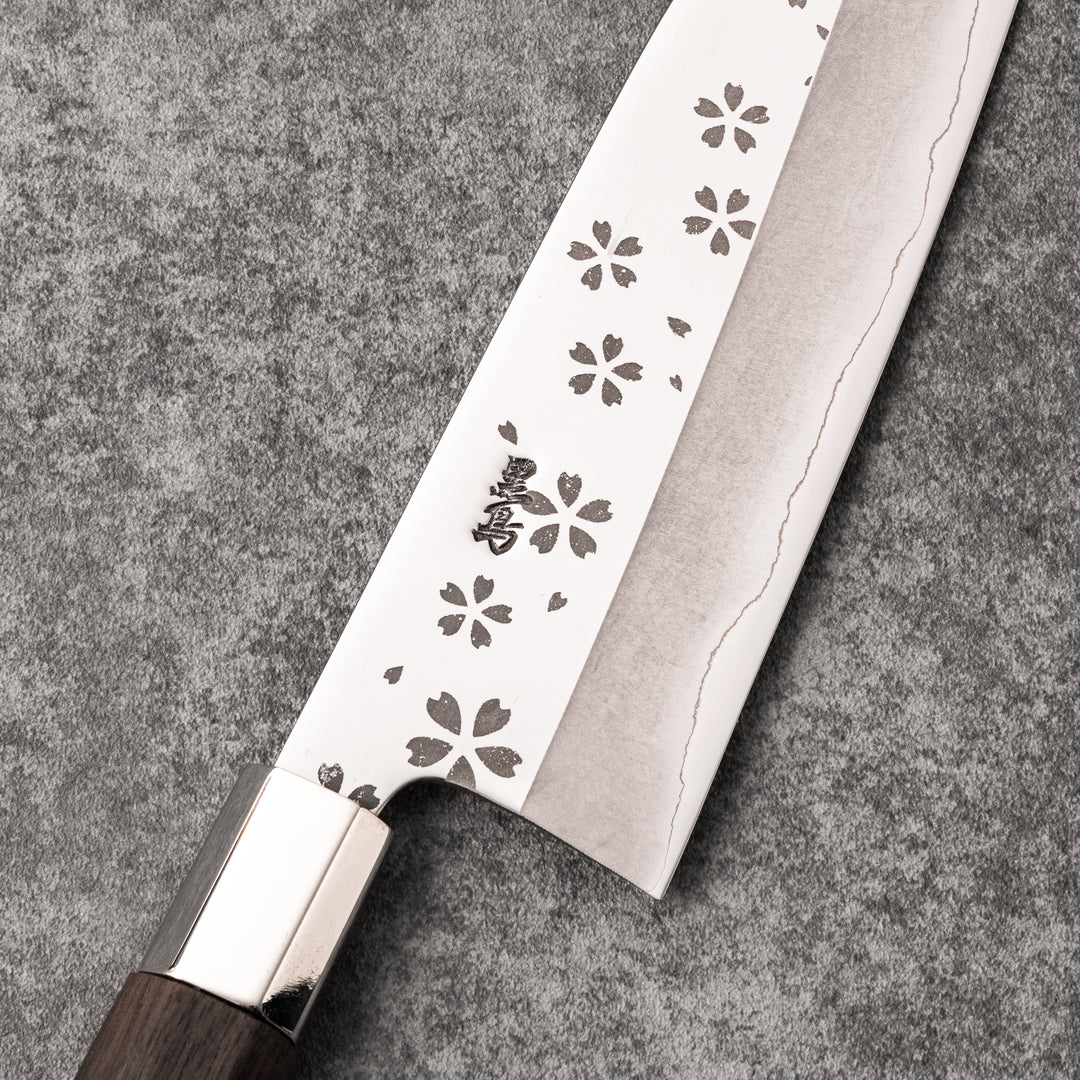 Elegant Japanese kitchen knife with cherry blossom cutout pattern on the blade, featuring a sharp edge and dark wooden handle for precise cutting.