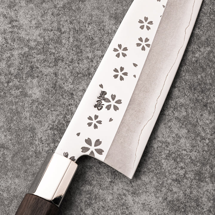 Elegant Japanese kitchen knife with cherry blossom cutout pattern on the blade, featuring a sharp edge and dark wooden handle for precise cutting.