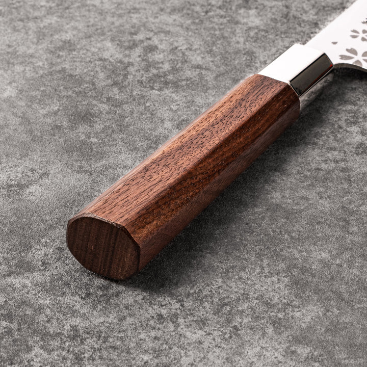 Elegant Japanese kitchen knife with cherry blossom cutout pattern on the blade, featuring a sharp edge and dark wooden handle for precise cutting.