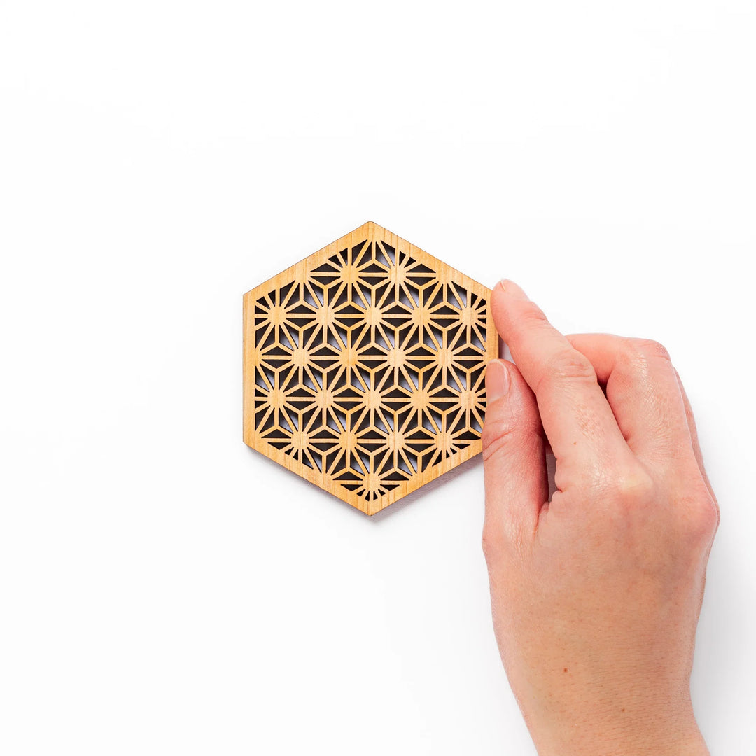 Hinoki wood coaster with a detailed hemp star cutout pattern in a hexagon shape against a white background.