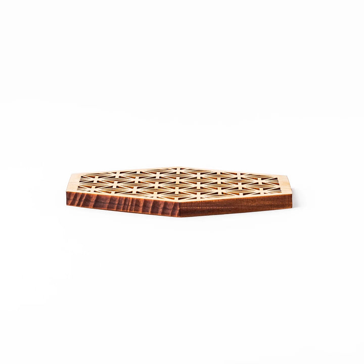 Hinoki wood coaster with a detailed hemp star cutout pattern in a hexagon shape against a white background.