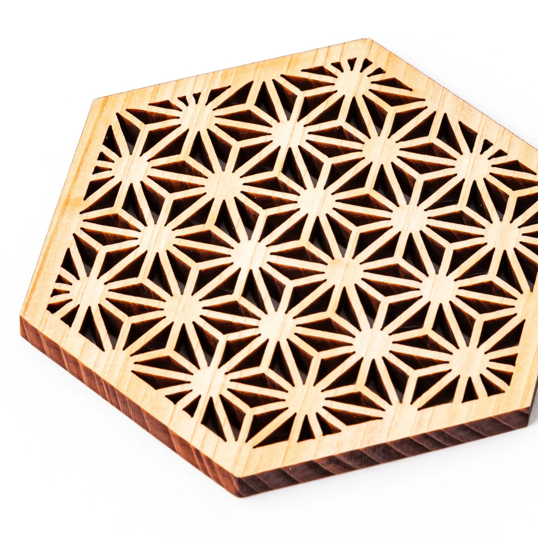 Hinoki wood coaster with a detailed hemp star cutout pattern in a hexagon shape against a white background.