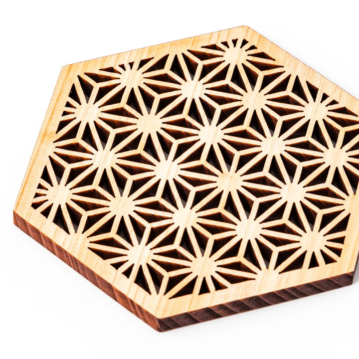 Hinoki wood coaster with a detailed hemp star cutout pattern in a hexagon shape against a white background.