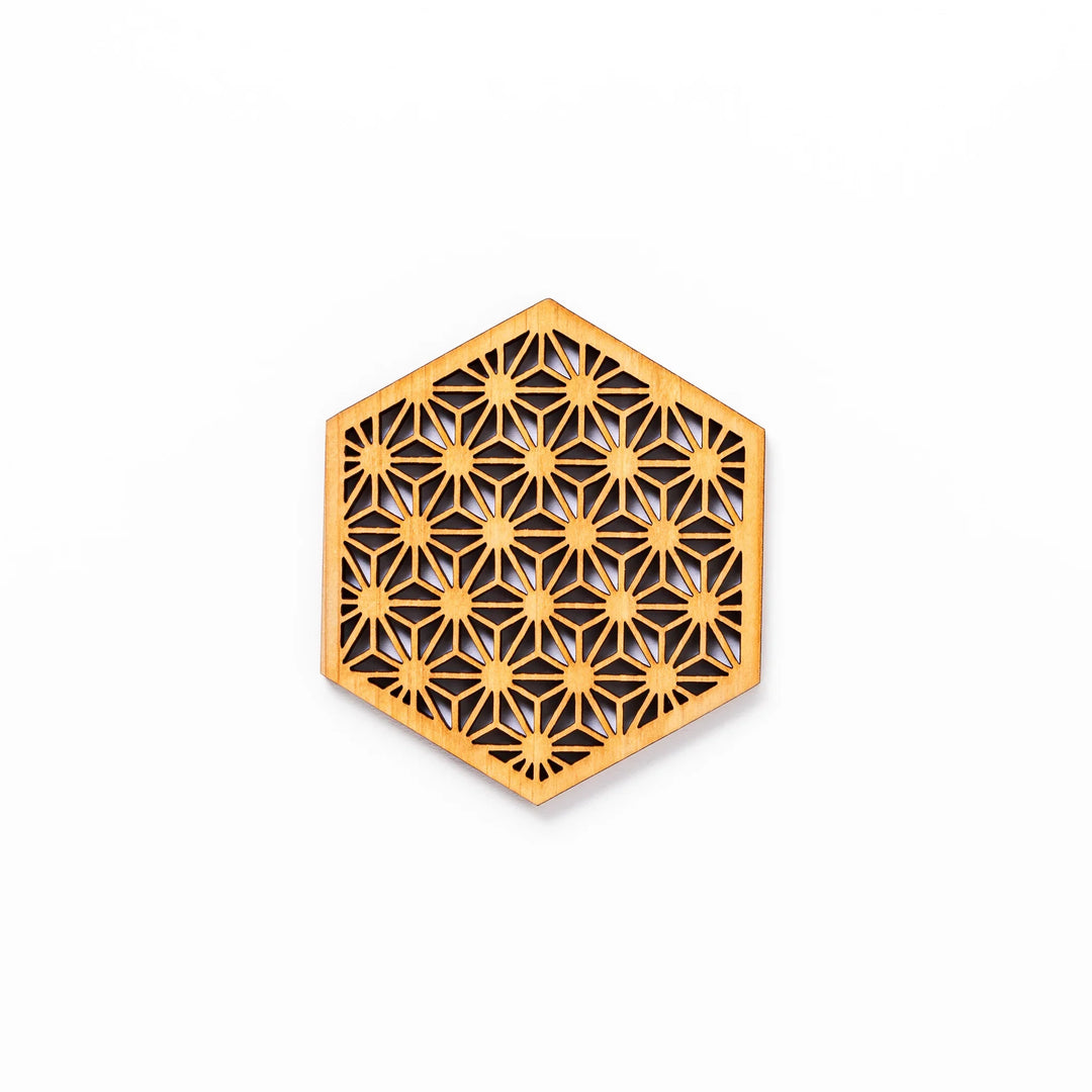 Hinoki wood coaster with a detailed hemp star cutout pattern in a hexagon shape against a white background.