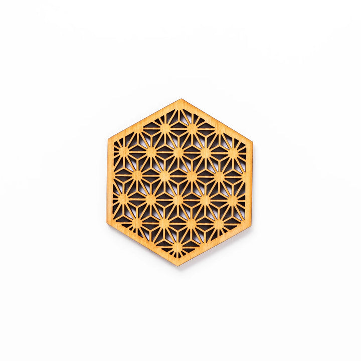 Hinoki wood coaster with a detailed hemp star cutout pattern in a hexagon shape against a white background.