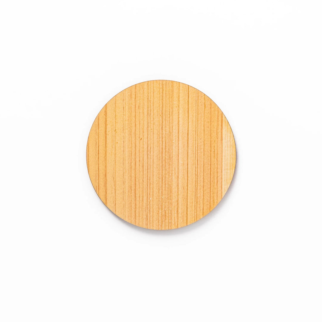 Round hinoki wood coaster with engraved sesame lattice pattern, featuring warm natural grain and a finely detailed geometric design.