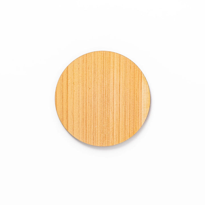 Round hinoki wood coaster with engraved sesame lattice pattern, featuring warm natural grain and a finely detailed geometric design.