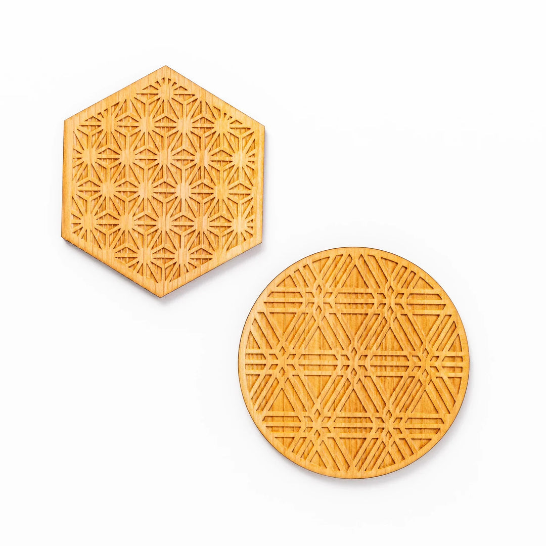 Handcrafted hinoki wood coasters with engraved hemp star and sesame lattice patterns arranged on a white background.