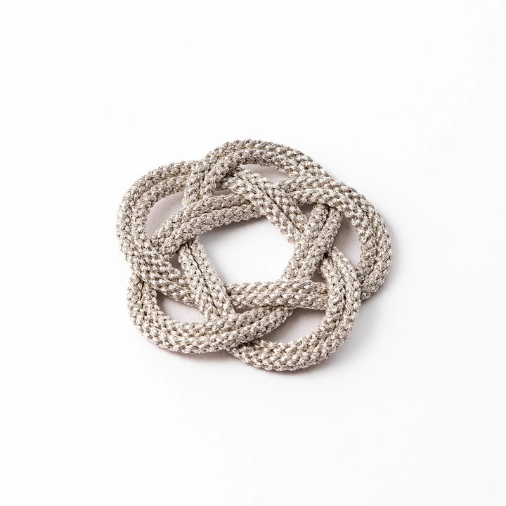 Silver decorative cushion with Japanese knot design for supporting mini prayer or meditation bowls elegantly.