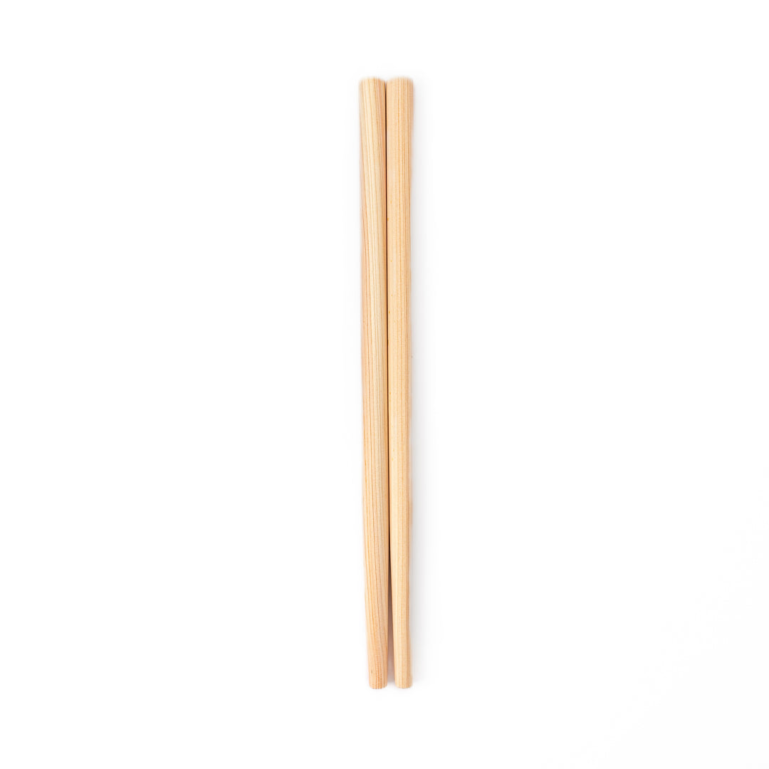 A pair of thick Japanese tempura cooking chopsticks made from light natural wood showcasing a minimalist and sturdy design