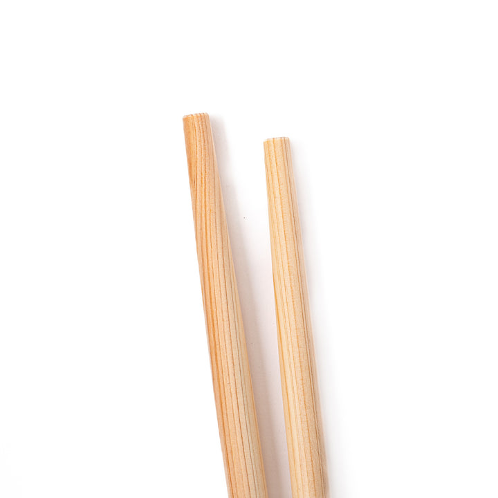 A pair of thick Japanese tempura cooking chopsticks made from light natural wood showcasing a minimalist and sturdy design