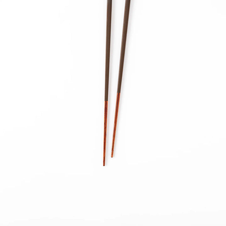 Pair of chestnut brown Japanese traditional color bamboo chopsticks with slim tips for refined and accurate dining