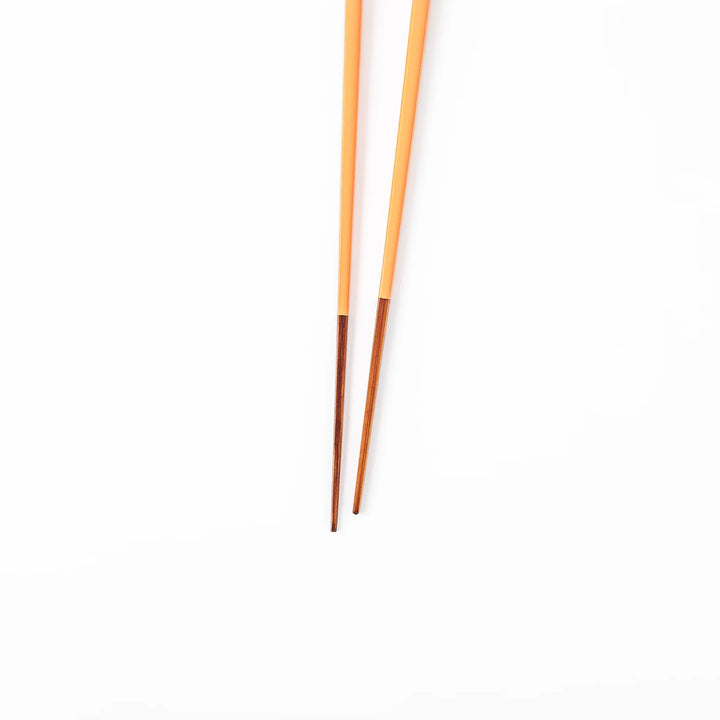 Pair of persimmon orange Japanese traditional color bamboo chopsticks with fine tips for precise and elegant dining