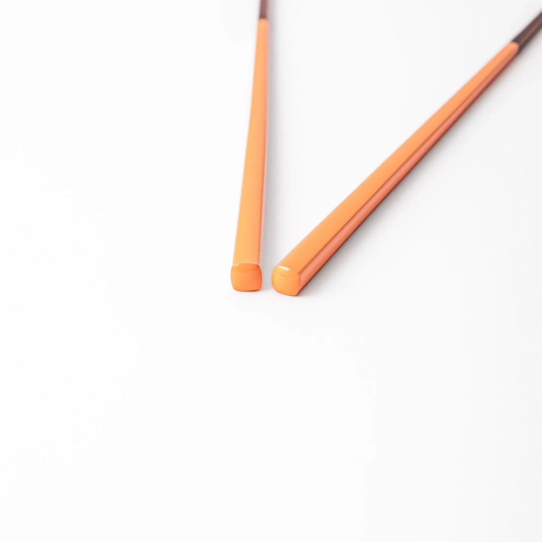 Pair of persimmon orange Japanese traditional color bamboo chopsticks with fine tips for precise and elegant dining