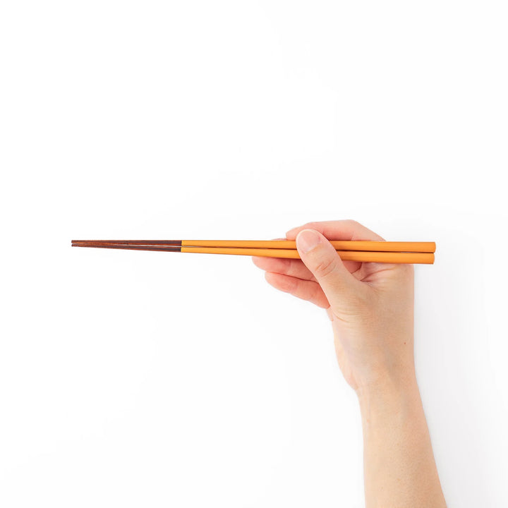 Pair of tangerine orange Japanese traditional color bamboo chopsticks with fine tips for a precise and elegant dining experience