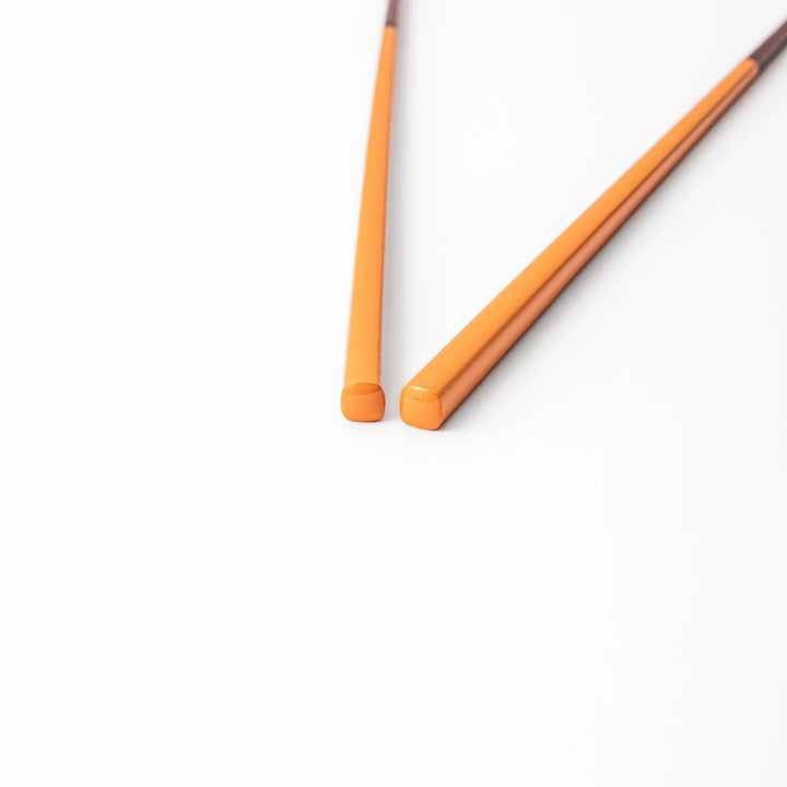 Pair of tangerine orange Japanese traditional color bamboo chopsticks with fine tips for a precise and elegant dining experience