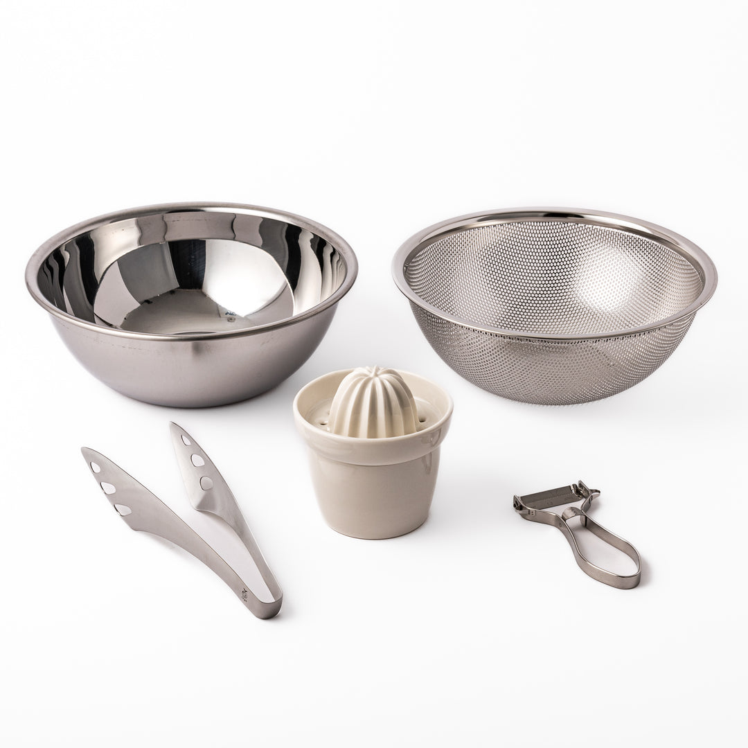 Japanese salad prep set featuring stainless steel mixing and strainer bowls, ceramic citrus juicer, peeler, and tongs, designed for effortless vegetable and dressing preparation.