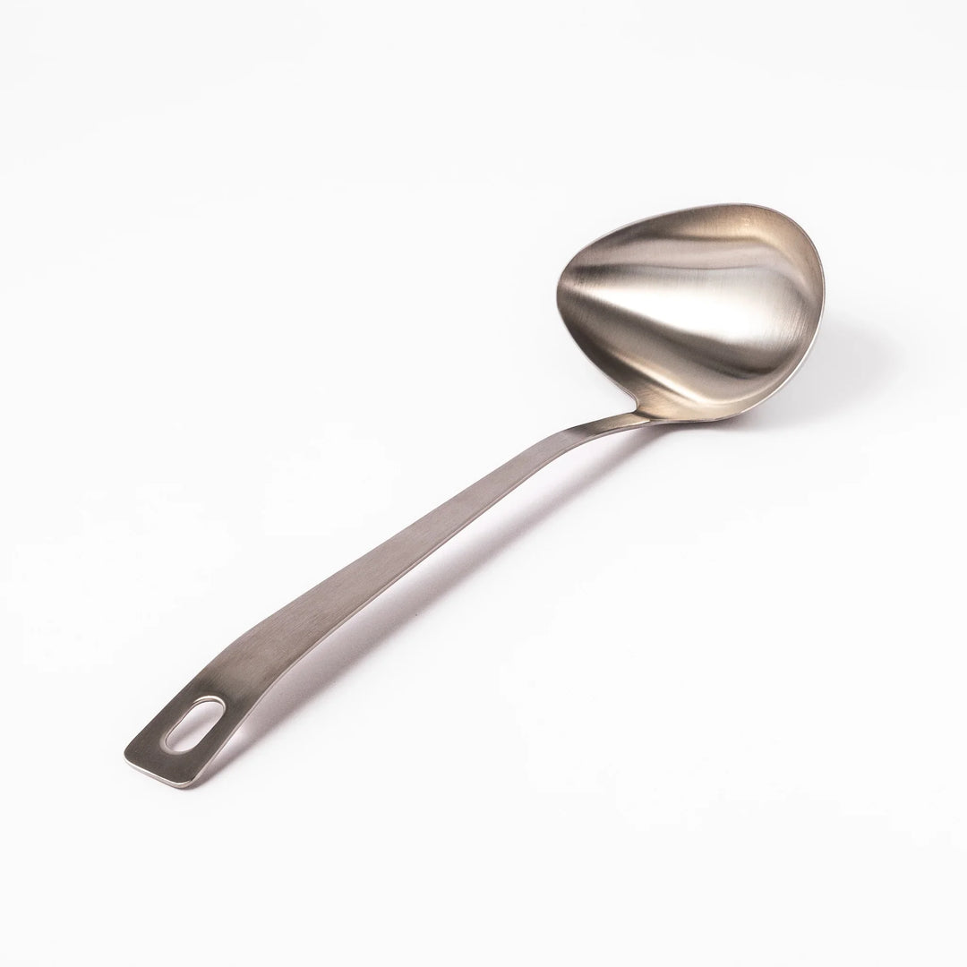 Japanese stainless steel soup ladle with long handle and deep curved bowl for serving soups and stews.