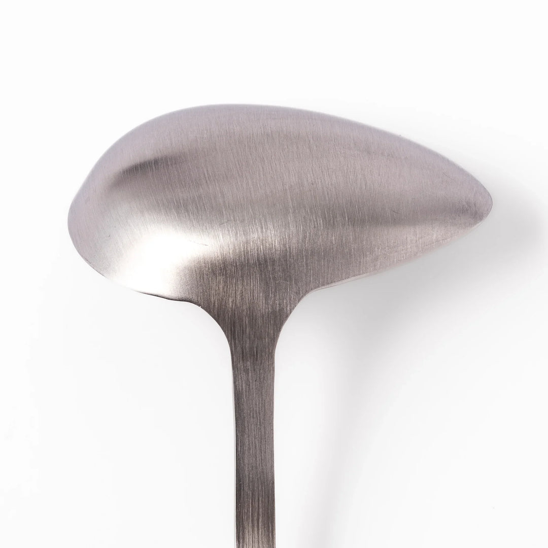Japanese stainless steel soup ladle with long handle and deep curved bowl for serving soups and stews.