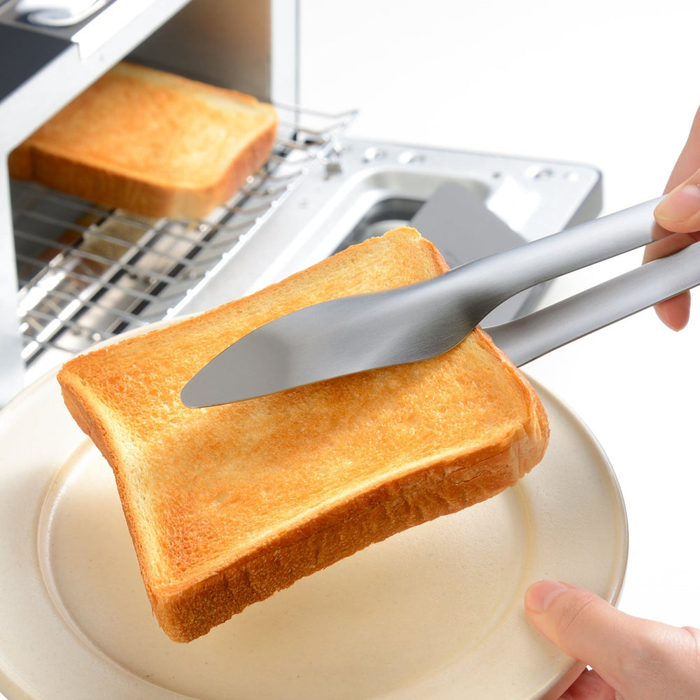 Stainless steel bread tongs removing freshly toasted bread from a toaster oven for a safe and easy breakfast