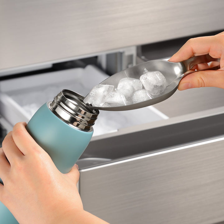 Stainless steel ice tongs funneling ice cubes into a narrow water bottle to prevent spills and keep drinks cold