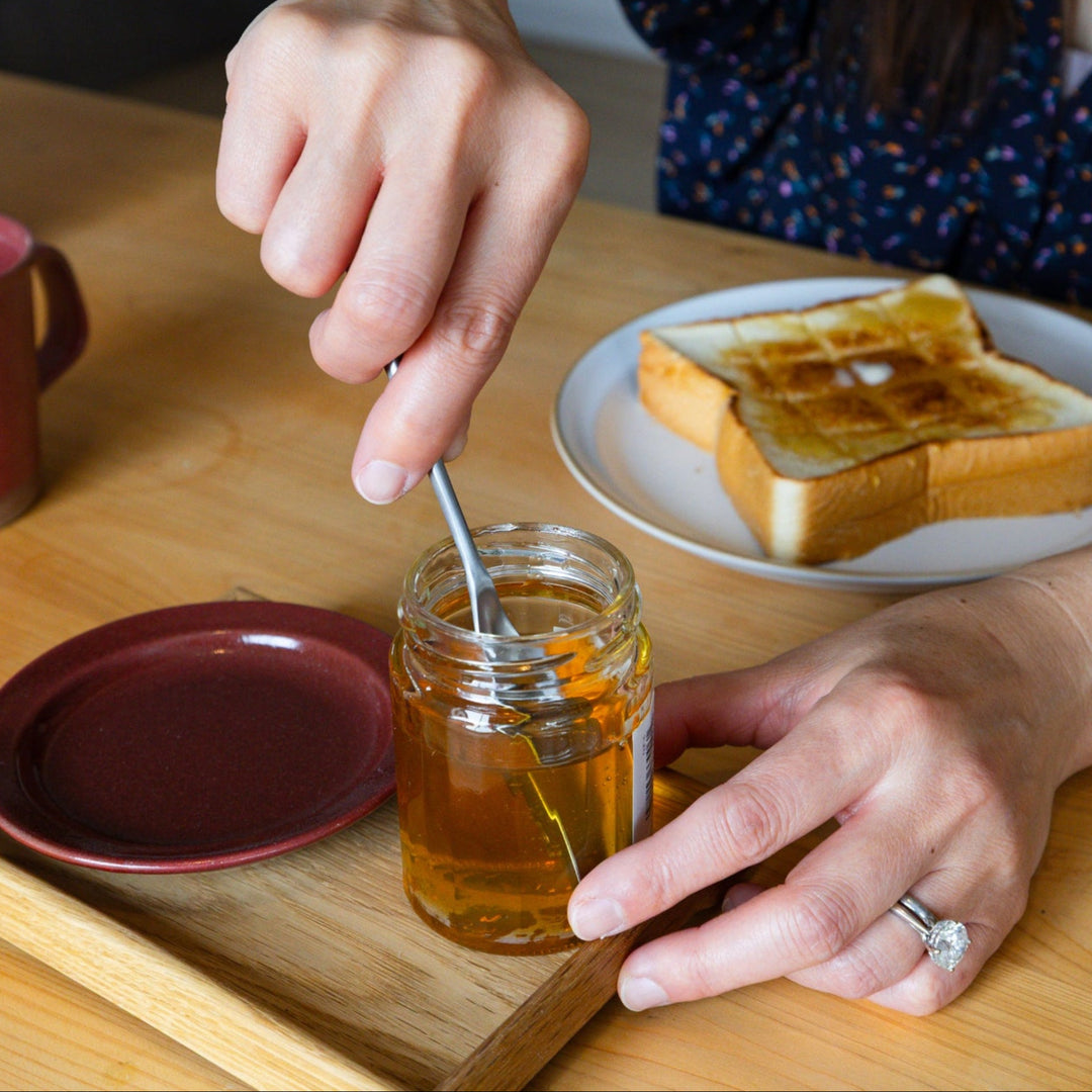 Nami dipping aux japanese honey spoon into jar sweet syrup breakfast table setting buttered toast cup