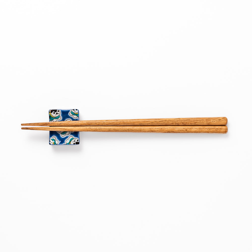 Rectangular Japanese ceramic chopstick rest with a deep blue background decorated with playful lucky dog motifs, bringing charm and fun to dining tables.