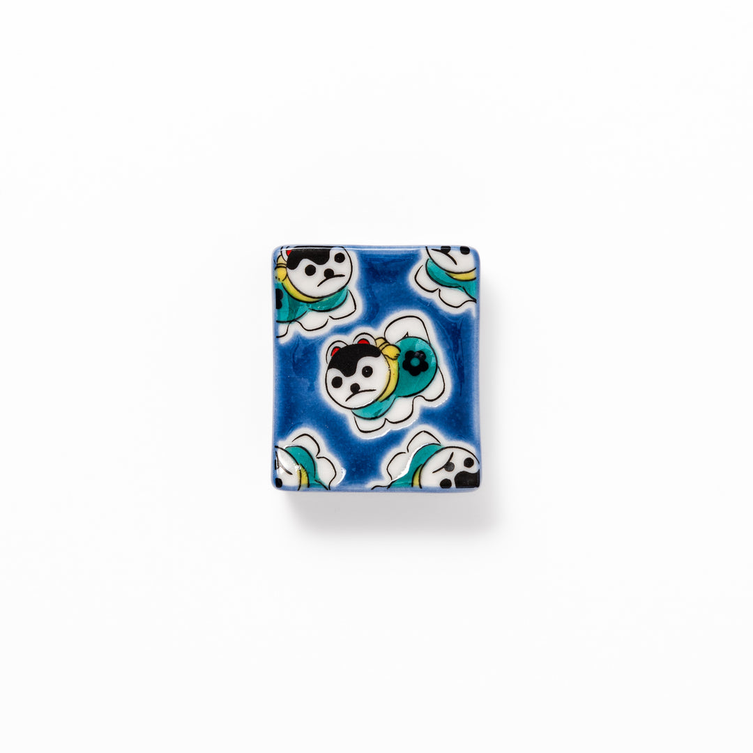 Rectangular Japanese ceramic chopstick rest with a deep blue background decorated with playful lucky dog motifs, bringing charm and fun to dining tables.