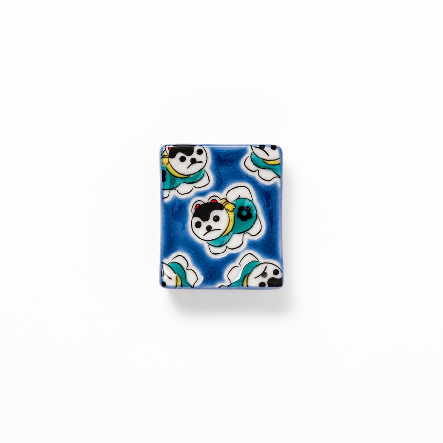 Rectangular Japanese ceramic chopstick rest with a deep blue background decorated with playful lucky dog motifs, bringing charm and fun to dining tables.