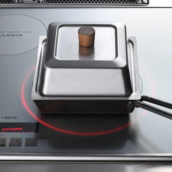 Square compact deep frying pan with stainless steel lid heating on an induction cooktop cooktop