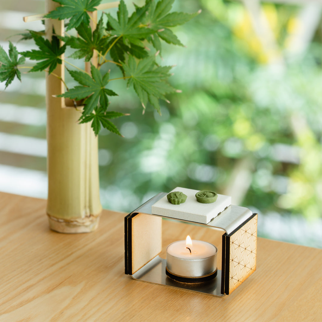 Matcha incense starter set with a modern ceramic candle warmer and green pressed incense on a wooden table
