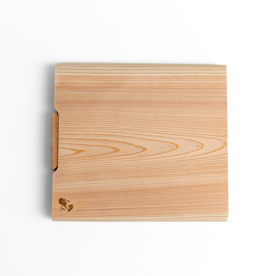 Medium Hinoki wood cutting board with natural grain, side handle, engraved motif, and smooth finish, crafted in Japan