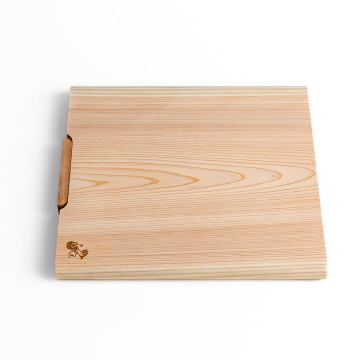 Medium Hinoki wood cutting board with natural grain, side handle, engraved motif, and smooth finish, crafted in Japan