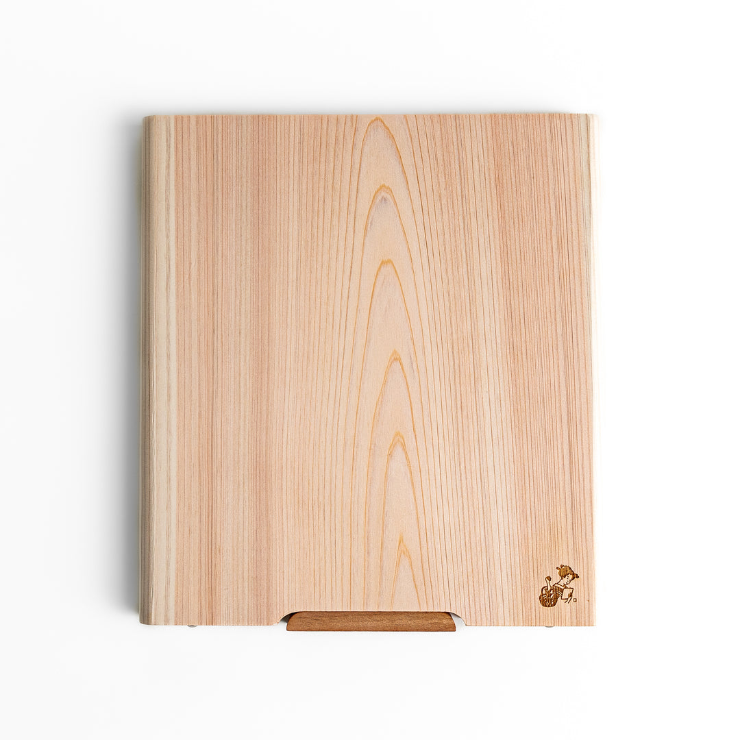 Medium Hinoki wood cutting board with natural grain, side handle, engraved motif, and smooth finish, crafted in Japan