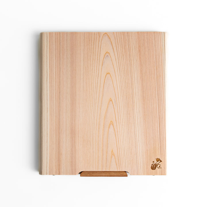 Medium Hinoki wood cutting board with natural grain, side handle, engraved motif, and smooth finish, crafted in Japan