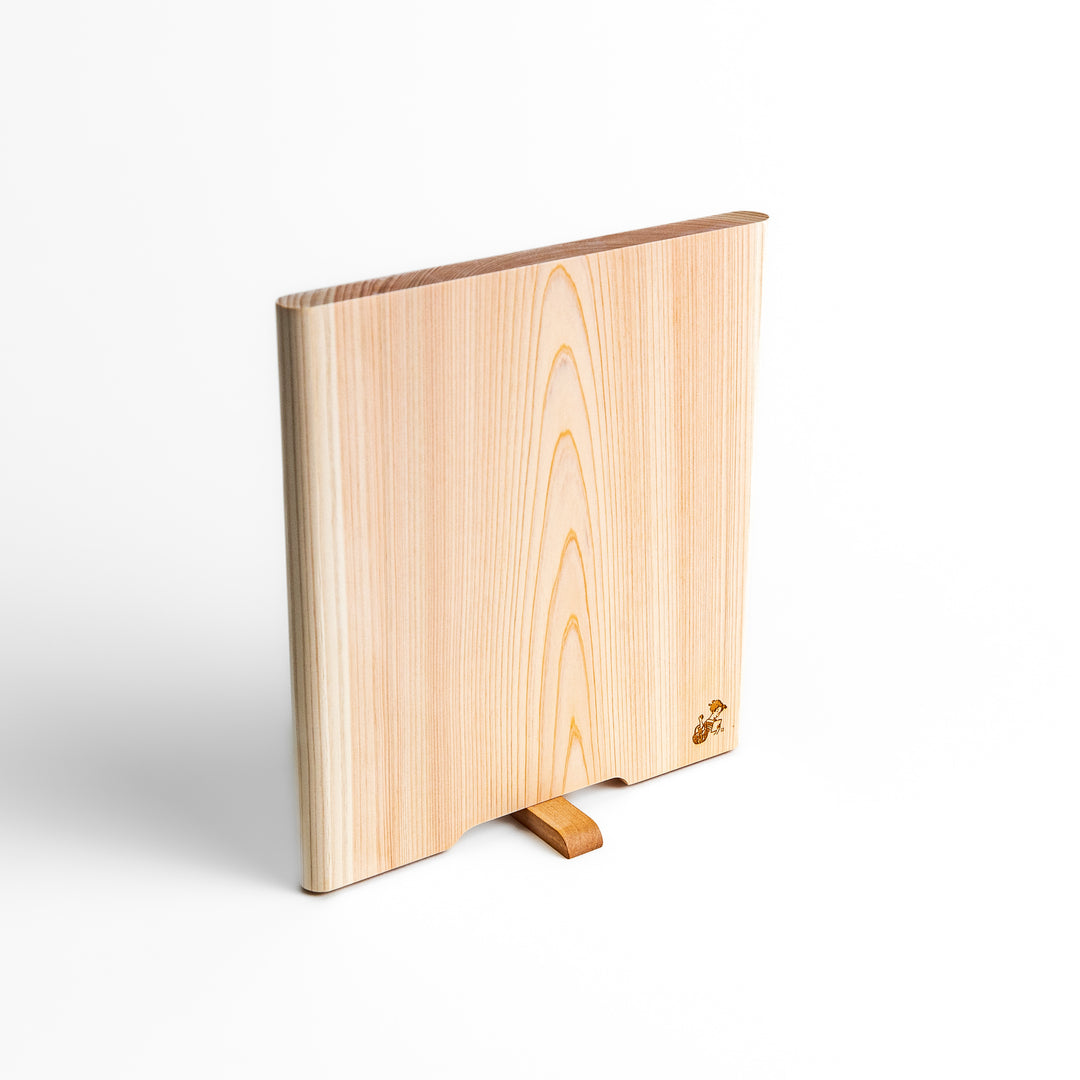 Medium Hinoki wood cutting board with natural grain, side handle, engraved motif, and smooth finish, crafted in Japan