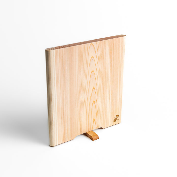 Medium Hinoki wood cutting board with natural grain, side handle, engraved motif, and smooth finish, crafted in Japan