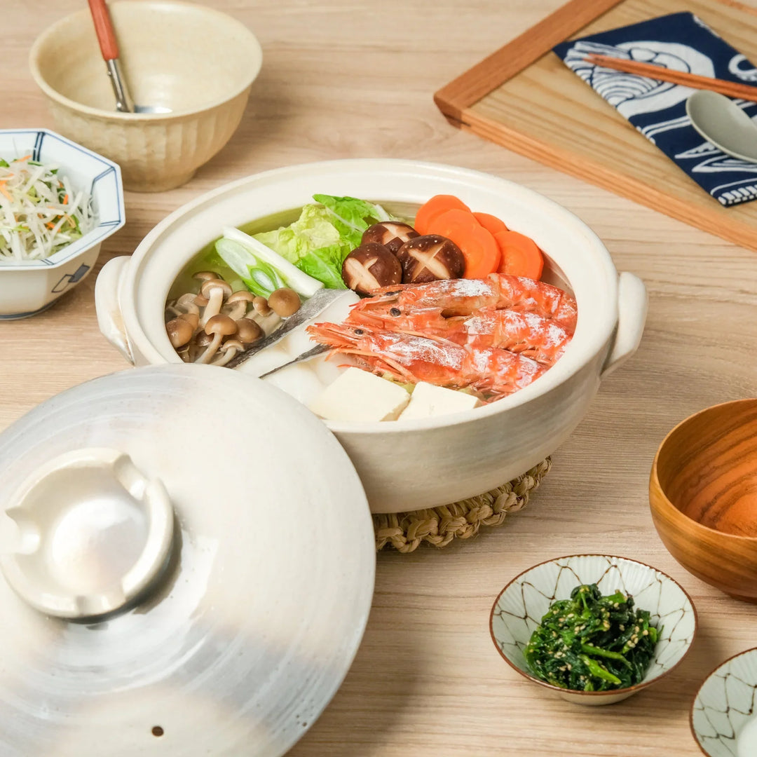 Japanese donabe clay pot filled with shrimp, tofu, mushrooms, and vegetables, ideal for hot pot cooking and cozy family meals.