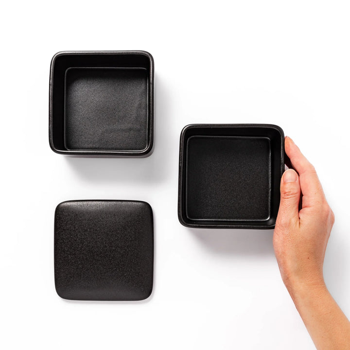 Sleek black Japanese porcelain bento box set, two-tiered design for modern, minimalist meal presentation and versatile storage.
