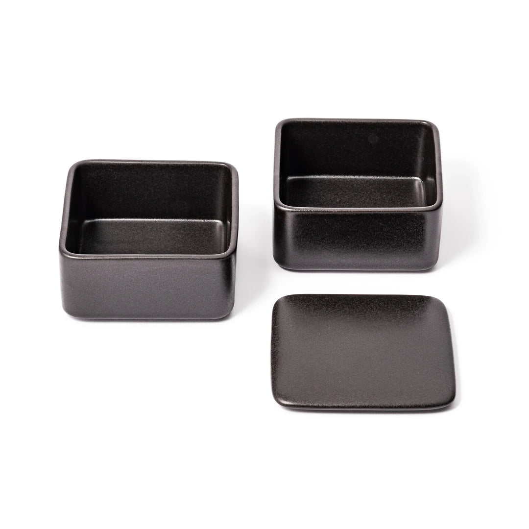 Sleek black Japanese porcelain bento box set, two-tiered design for modern, minimalist meal presentation and versatile storage.
